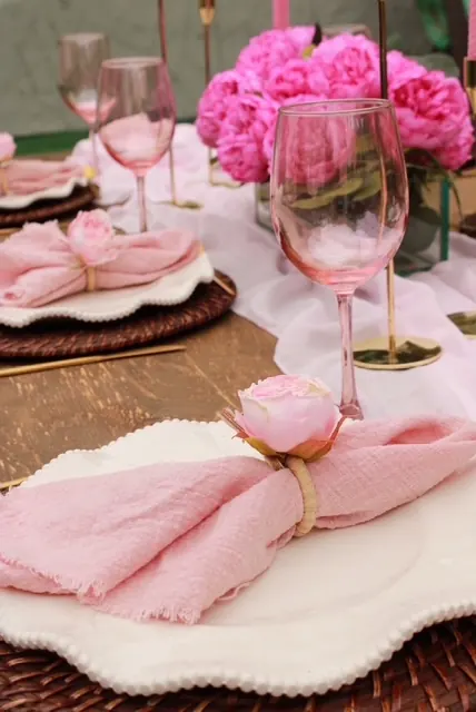 Blush peonies and delicate pink details at a garden place setting