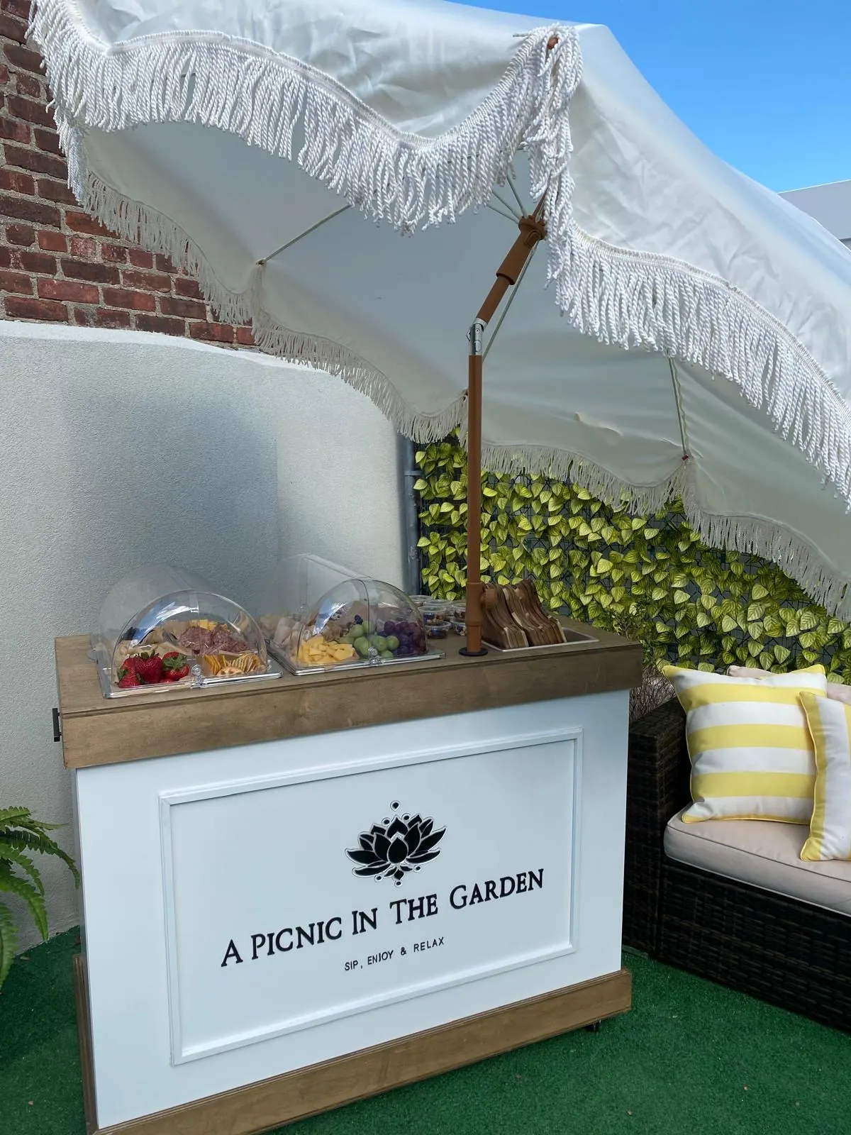 Charcuterie cart beneath a fringed umbrella